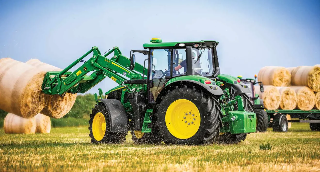 Tractor moving hay bales