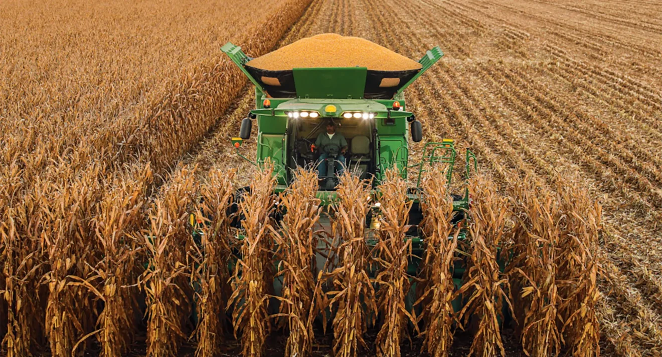 Farmer in combine harvesting in an open field