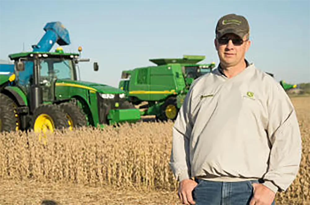 Doug Olson in the field with machinery in the background