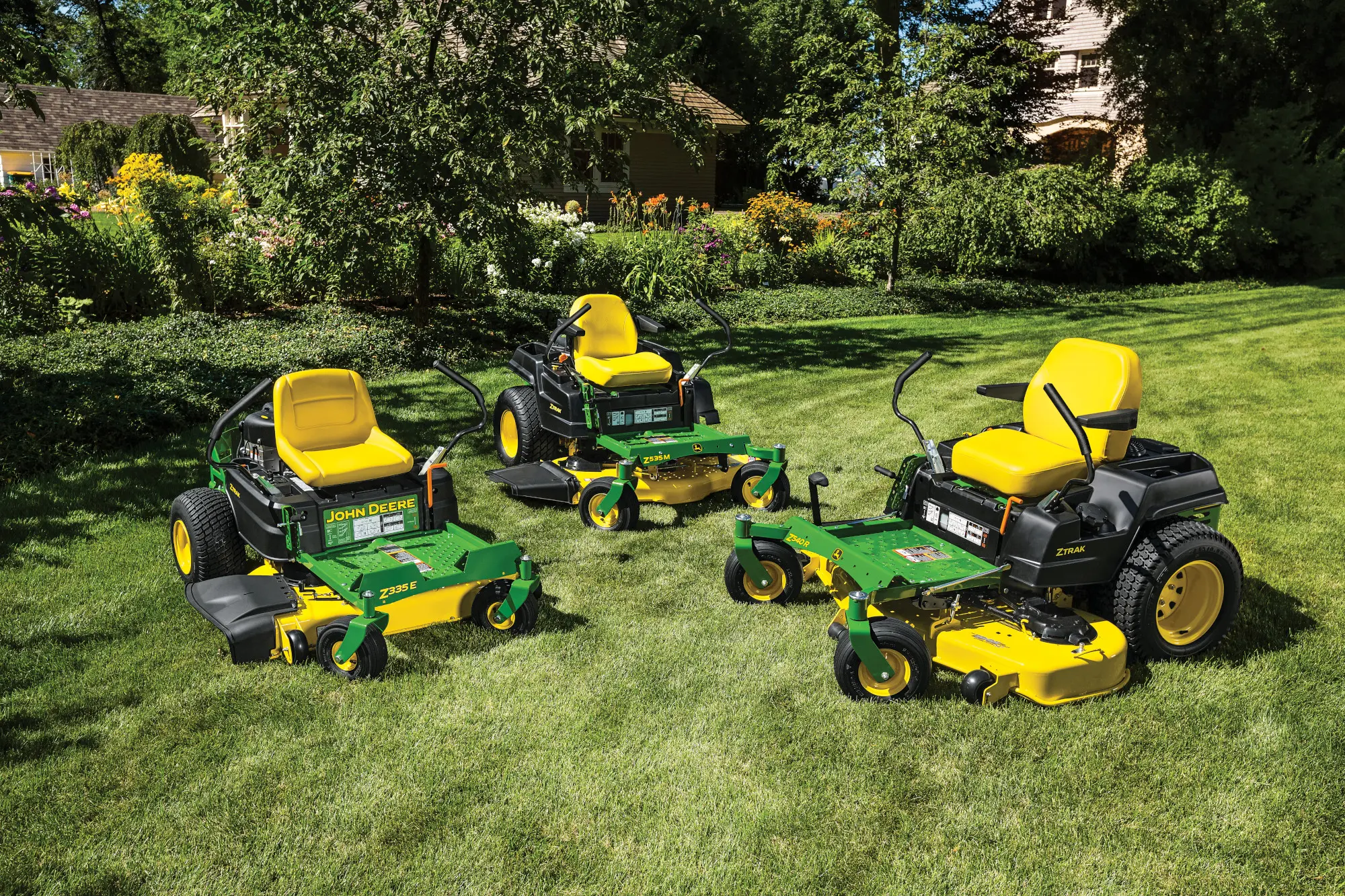Riding mowers being showcased together in a residential yard